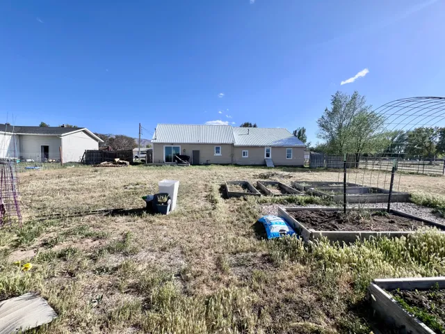 Back of property featuring a garden and a metal roof