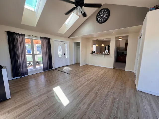 Vaulted ceiling featuring skylights and a ceiling fan