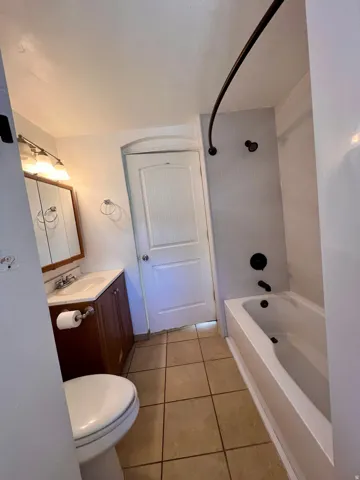 Bathroom featuring a full vanity with a wood-finish cabinet, white basin, and a mirrored medicine cabinet