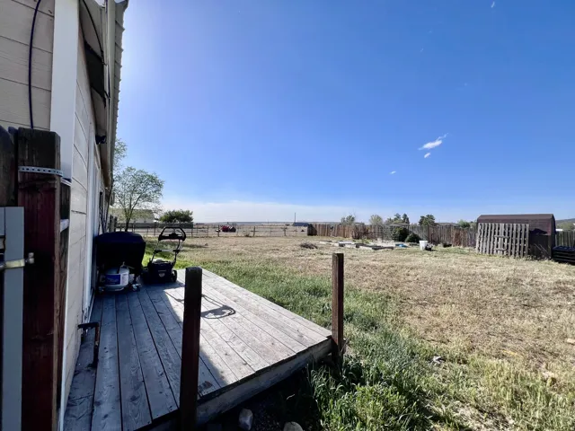 Fenced backyard featuring a deck and a rural view