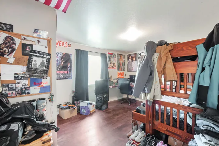 Bedroom with wood finished floors and a desk