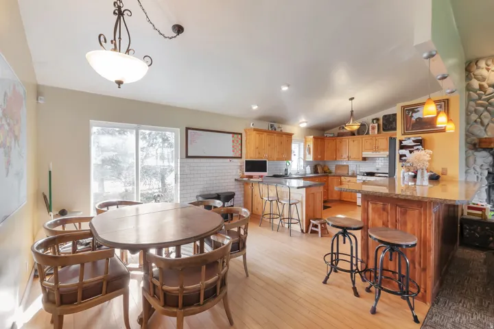 Dining room featuring vaulted ceiling and light wood-style floors