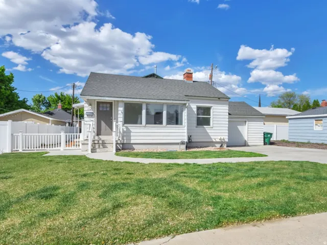 Bungalow with a garage, a shingled roof, and a chimney