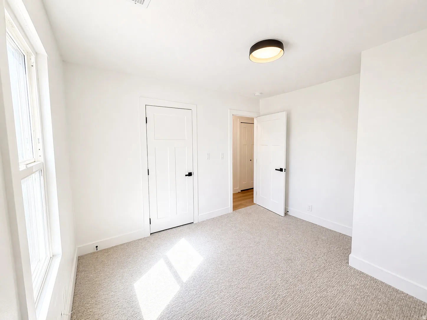 Unfurnished bedroom featuring light colored carpet and baseboards