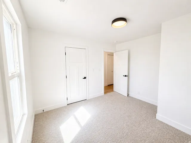 Unfurnished bedroom featuring light colored carpet and baseboards