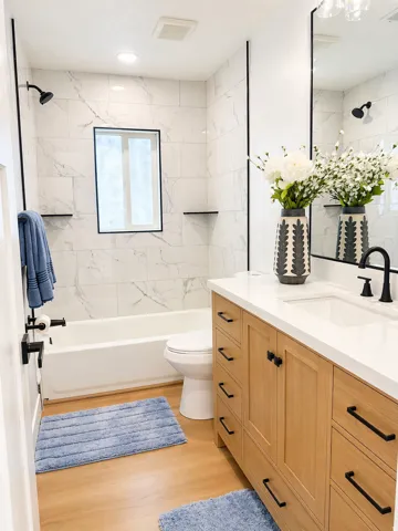 Full bath featuring vanity, bathtub / shower combination, and light wood-style flooring