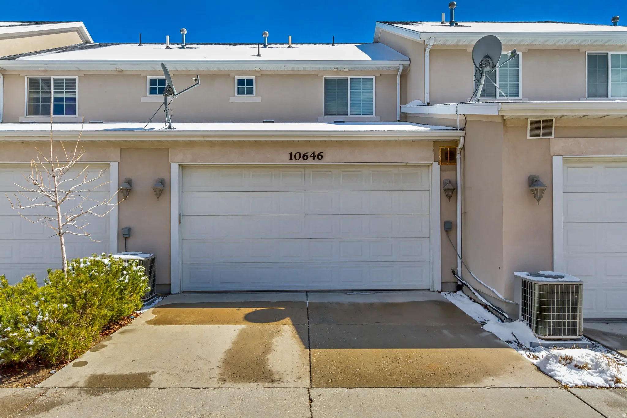 View of front of home featuring driveway, an attached garage, and stucco siding