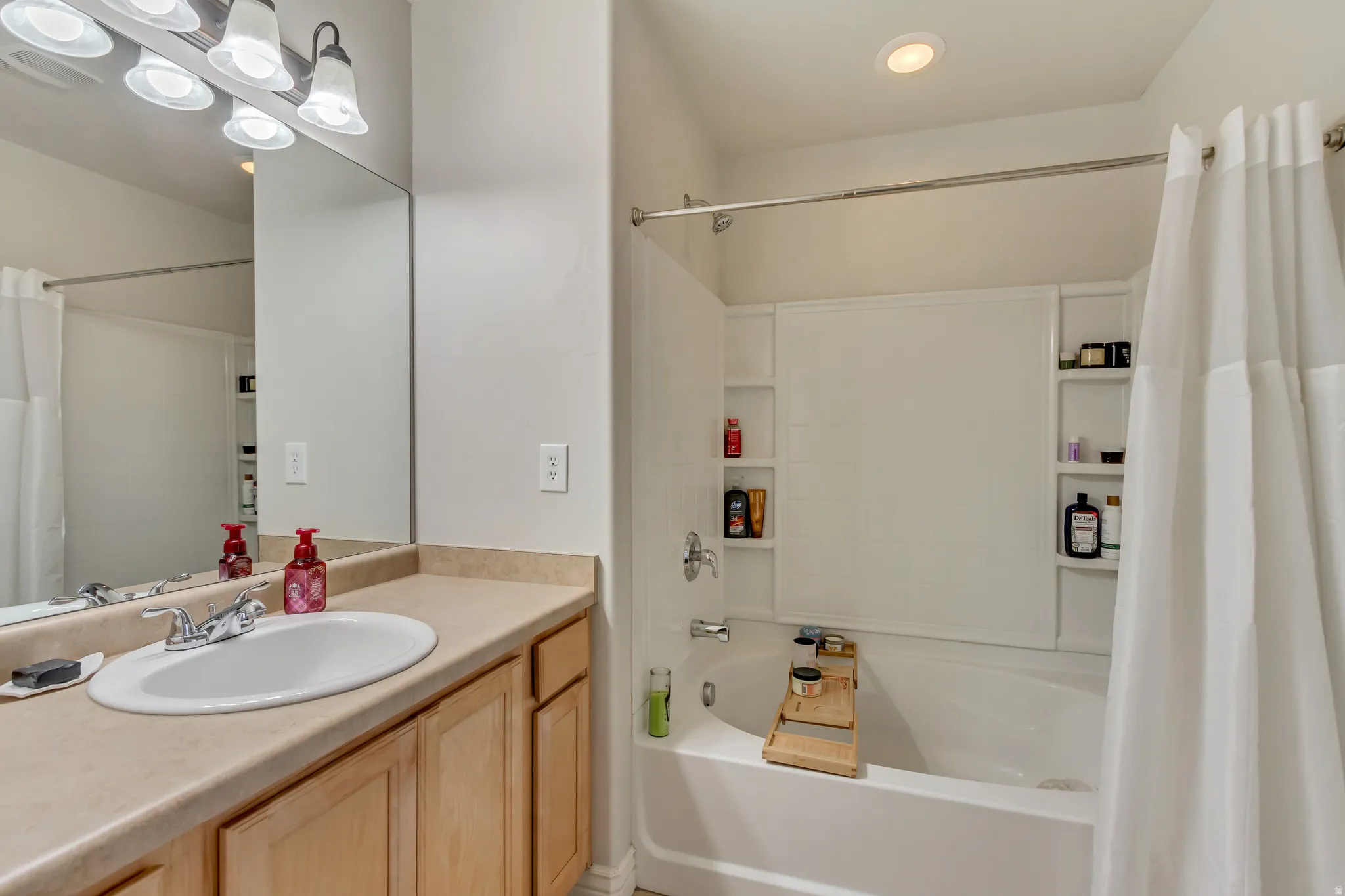 Full bath featuring vanity and shower / bathtub combination with curtain