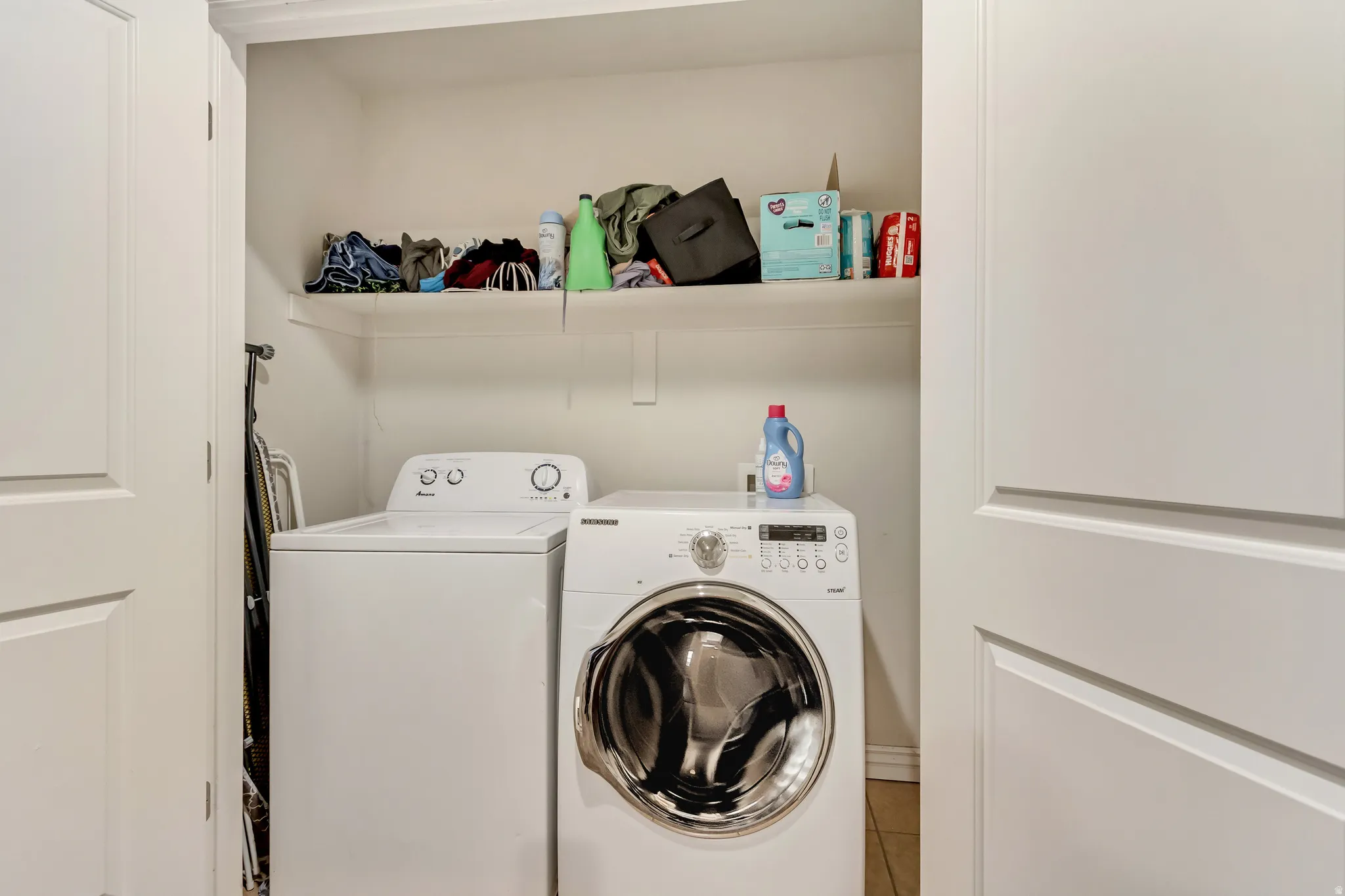Laundry area with washing machine and dryer and tile patterned floors