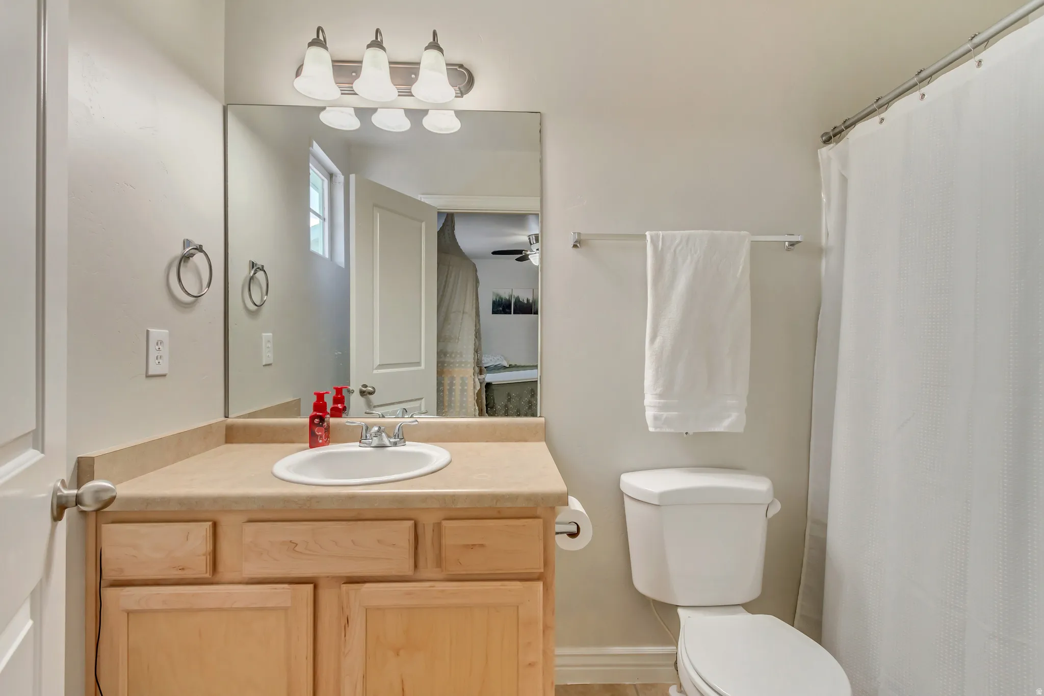 Full bath with vanity and a shower with shower curtain