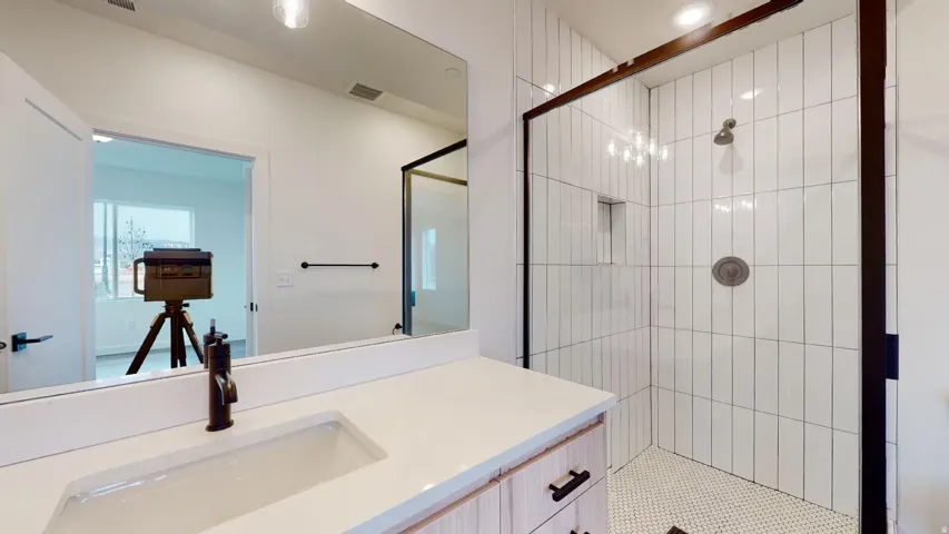 Full bath featuring a stall shower and vanity