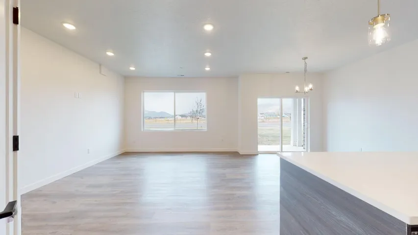 Unfurnished dining area featuring light wood-style floors and suspended lighting