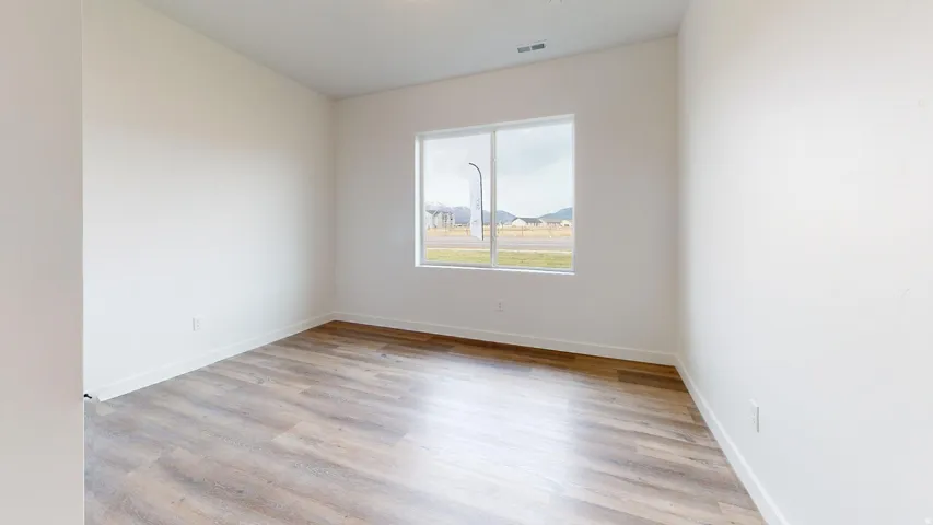 Empty room featuring light wood finished floors and baseboards