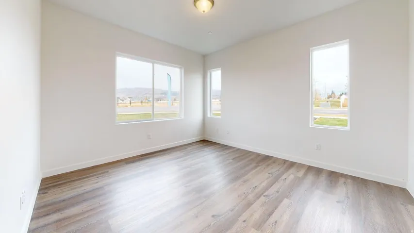 Unfurnished room featuring light wood-style flooring and baseboards