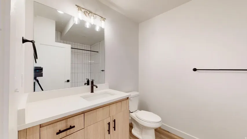 Full bath with vanity, a shower, and light wood-type flooring