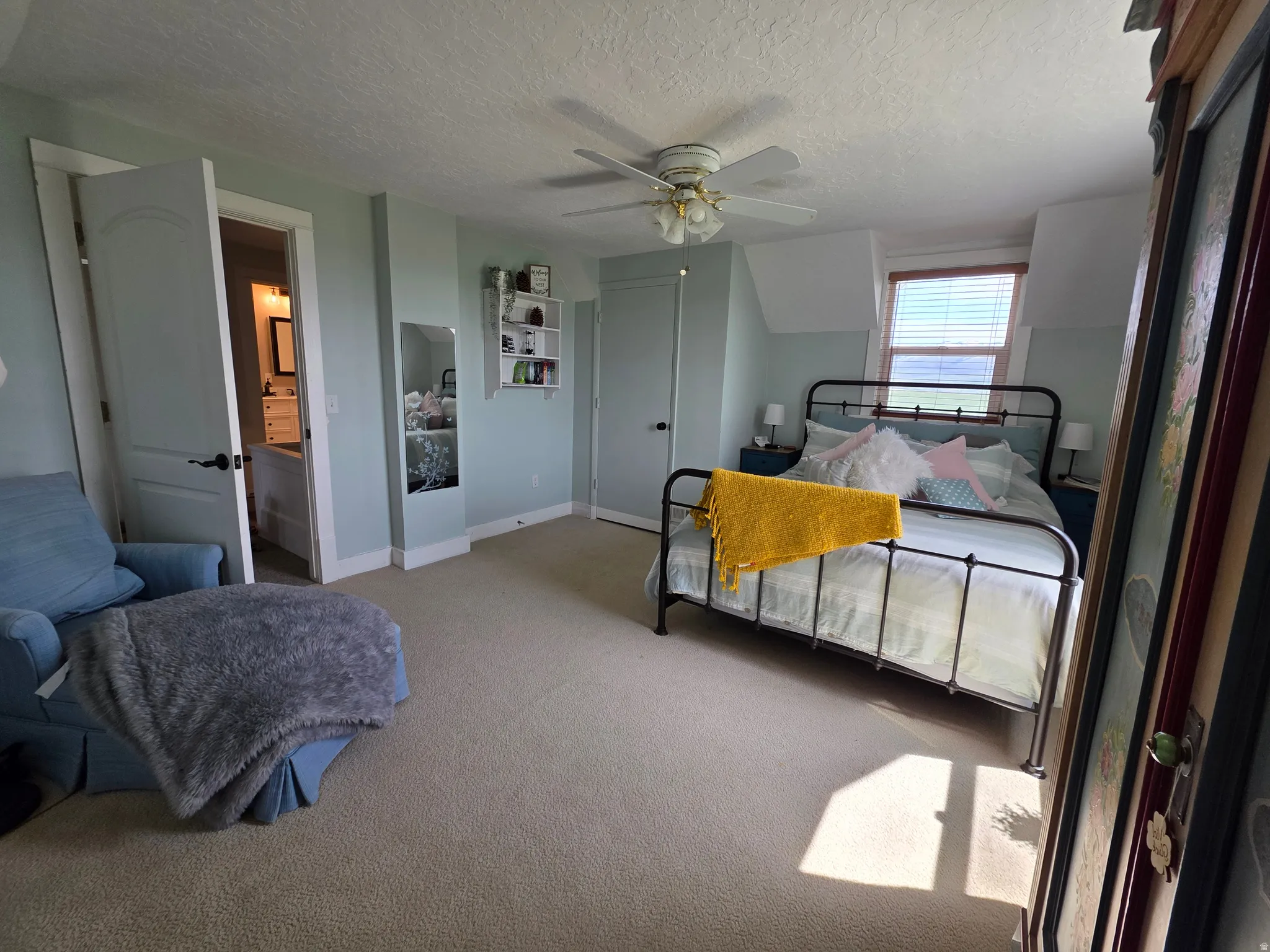 Bedroom with carpet flooring, a textured ceiling, and a ceiling fan