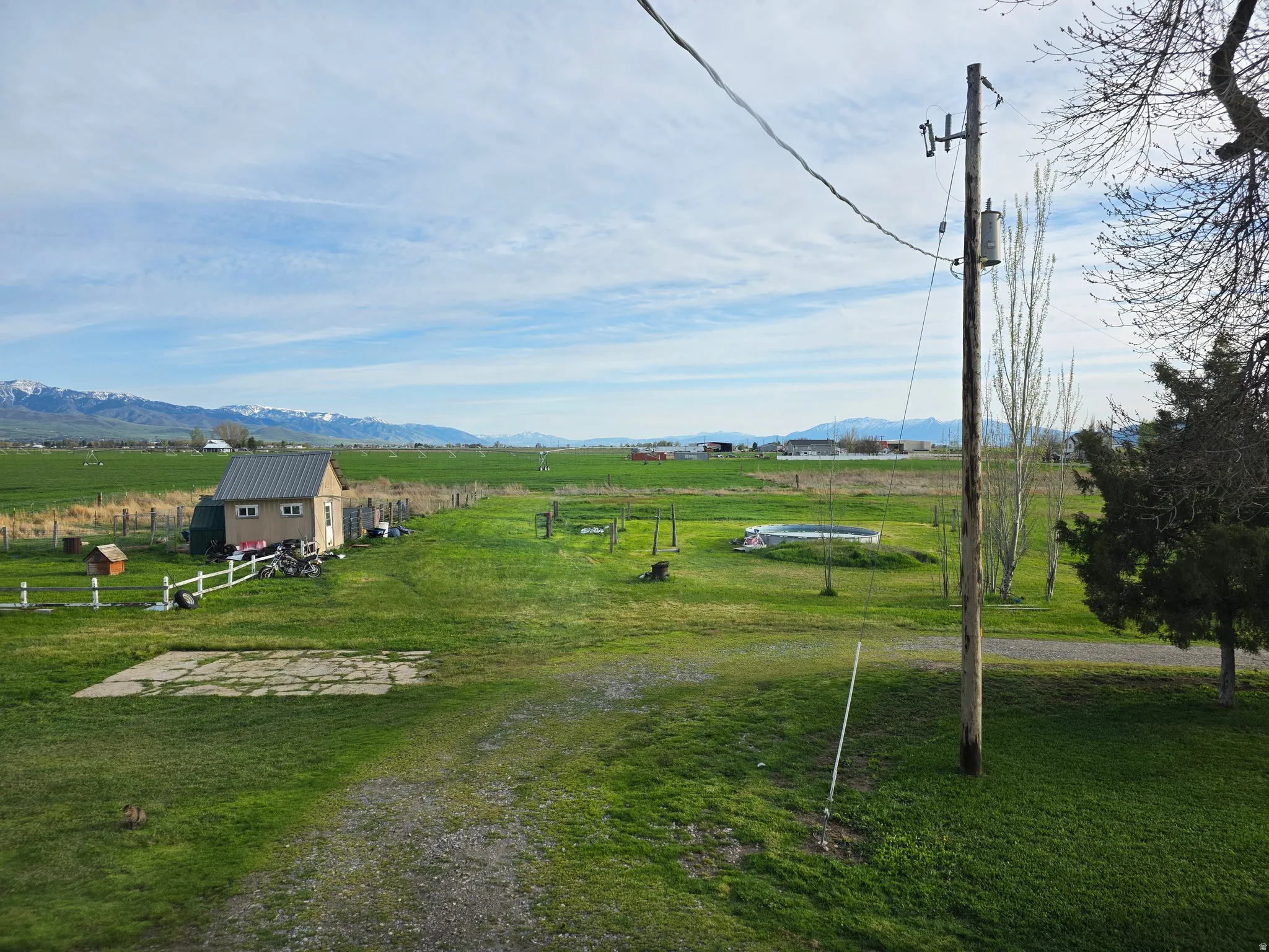 View of green lawn featuring a rural view, an outbuilding, and a mountain view