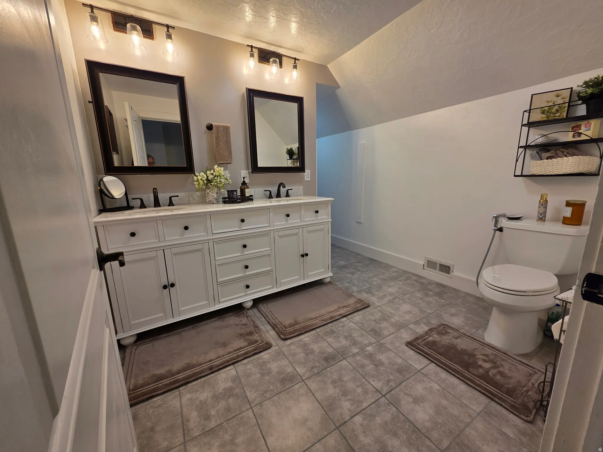 Bathroom with double vanity and light tile patterned floors