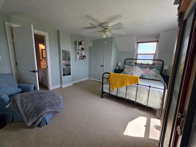 Bedroom with carpet flooring, a textured ceiling, and a ceiling fan
