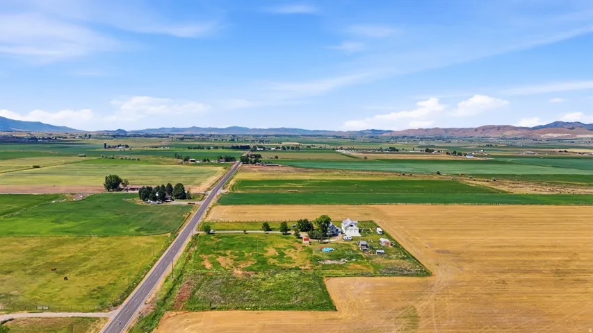 Expansive aerial landscape featuring agricultural fields and distant mountainous terrain