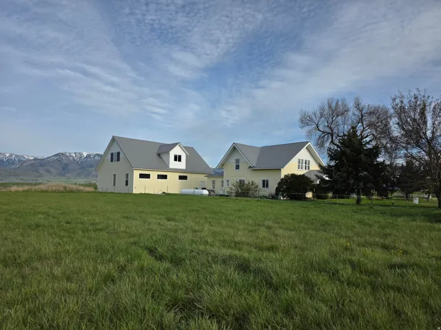View of front facade featuring a front lawn, a metal roof, and a mountain view