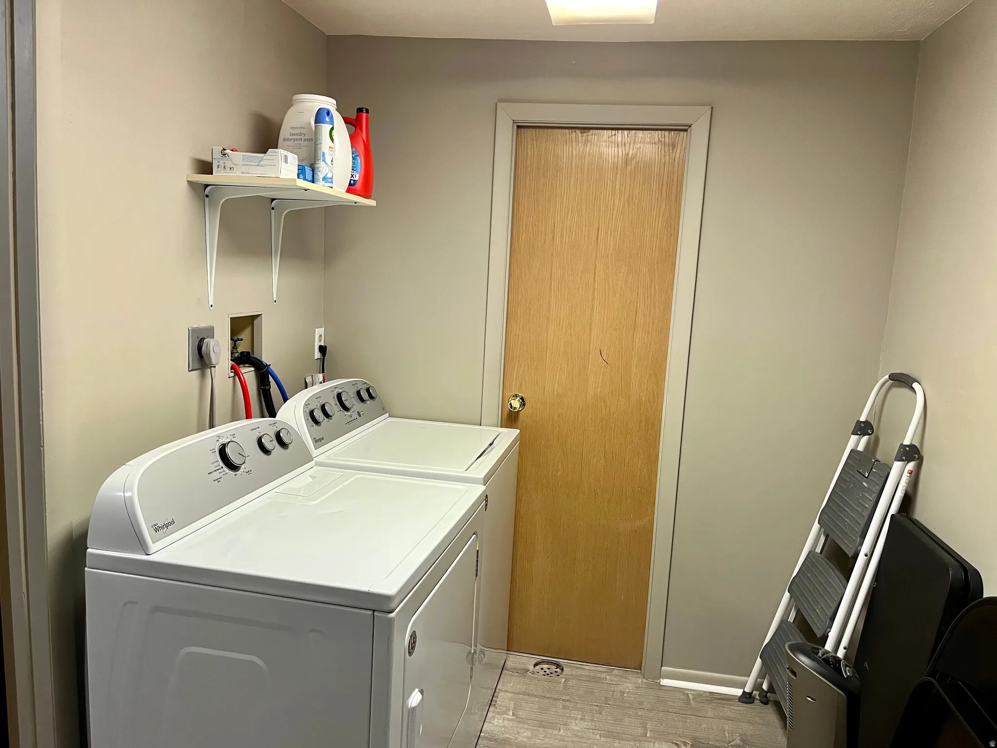 Laundry room with light wood-style floors and washer and dryer
