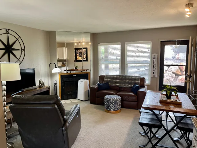 Carpeted living area featuring a fireplace