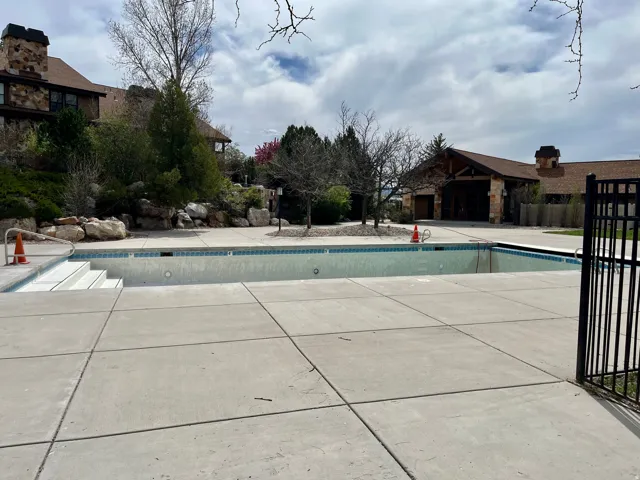 Fenced pool area with hot tub