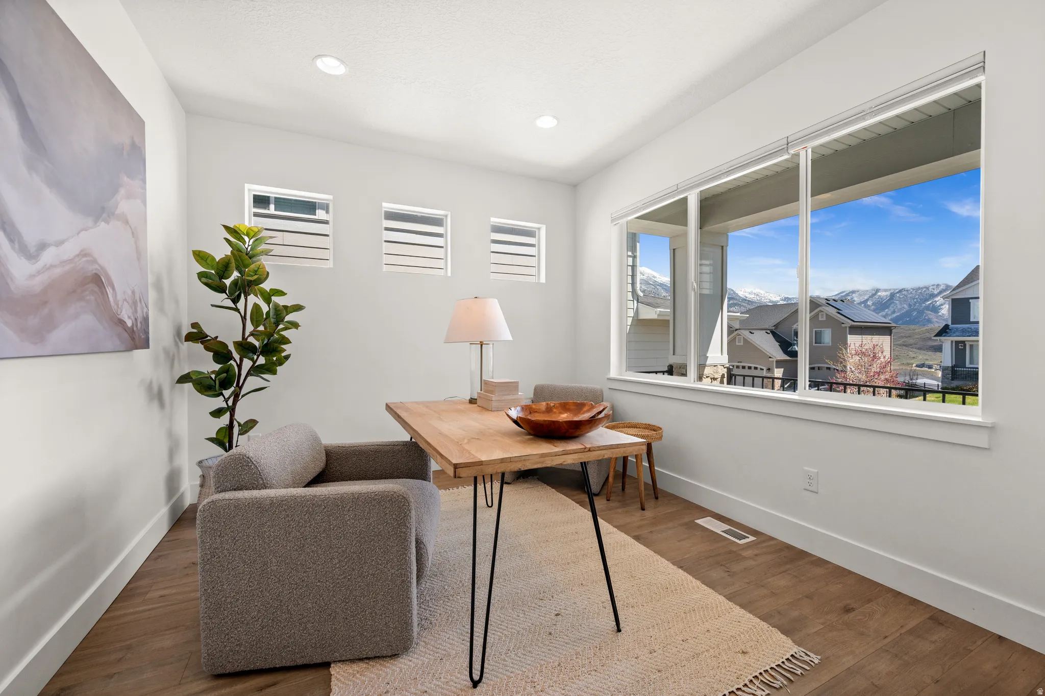 Office area with a mountain view, wood finished floors, healthy amount of natural light, and recessed lighting