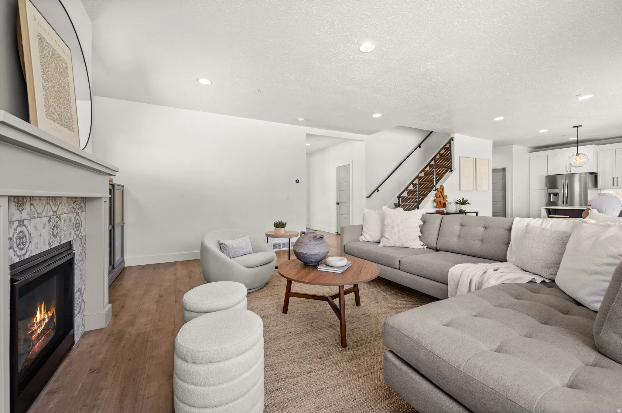 Living area with a fireplace, light wood-style floors, and recessed lighting