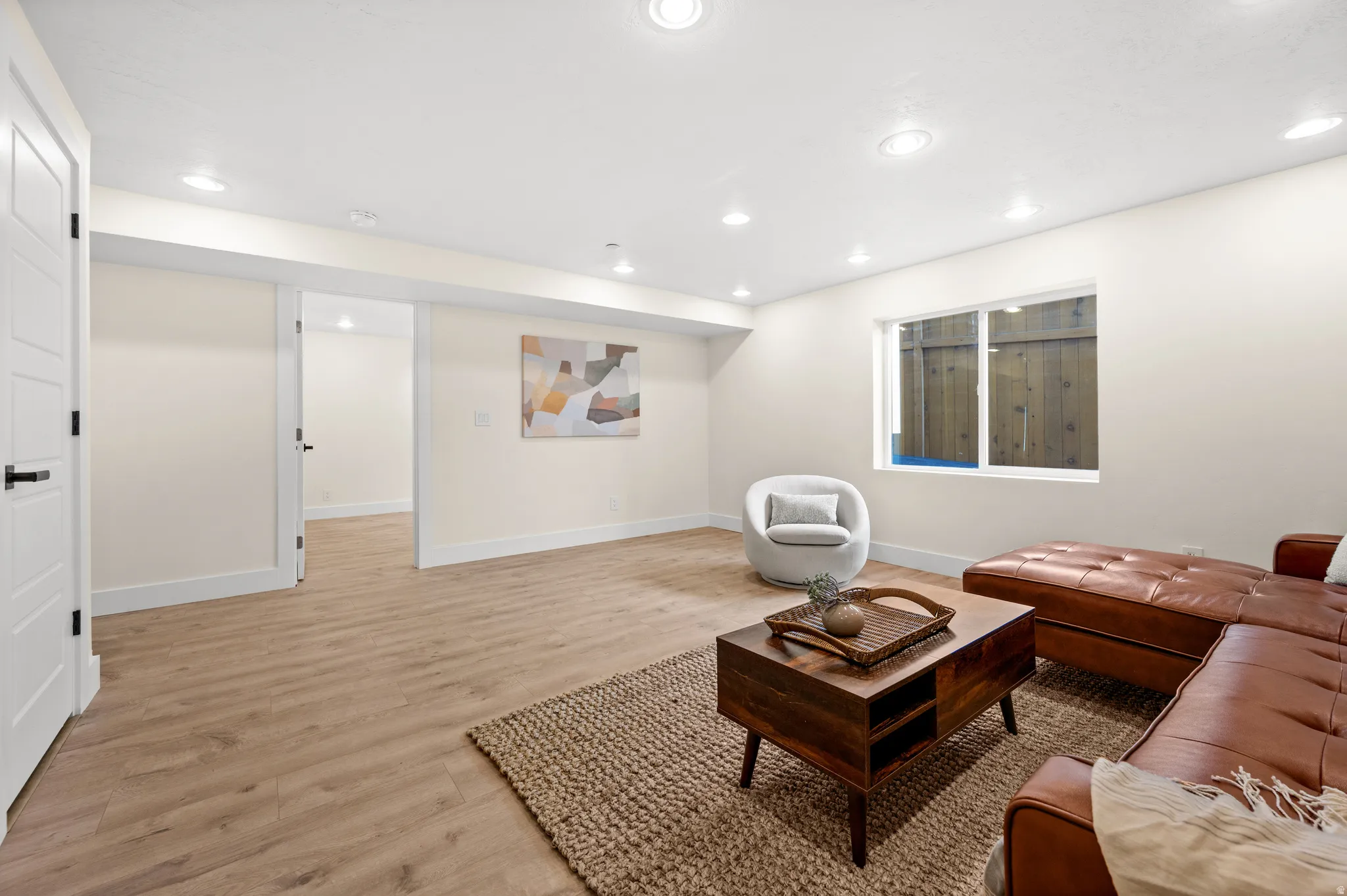 Living area with light wood-style flooring and recessed lighting