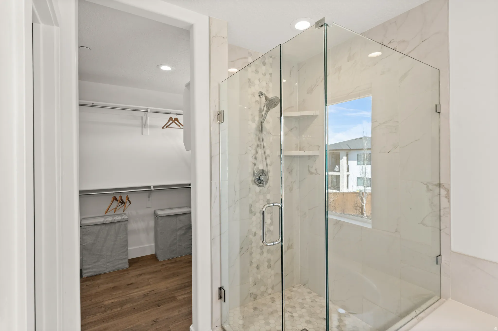 Full bath with a walk in closet, a marble finish shower, dark wood-style floors, and recessed lighting