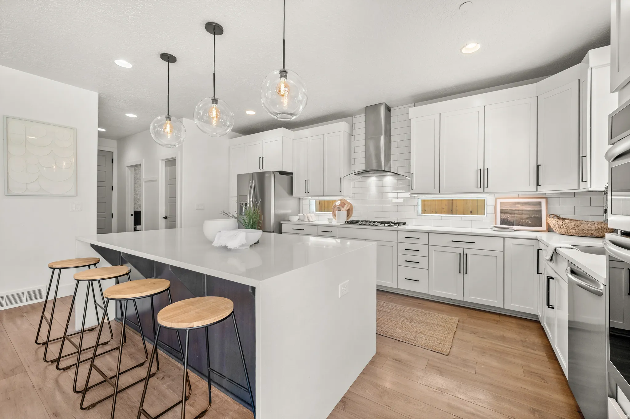 Kitchen with white cabinetry, light stone countertops, and a kitchen bar