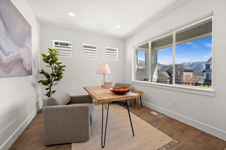 Office area with a mountain view, wood finished floors, healthy amount of natural light, and recessed lighting