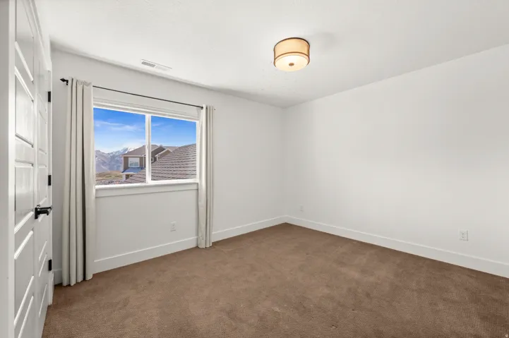Unfurnished room with baseboards and dark carpet
