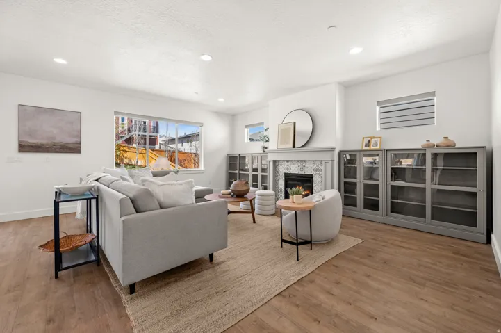 Living area featuring a tile fireplace, light wood-style flooring, recessed lighting, and a textured ceiling