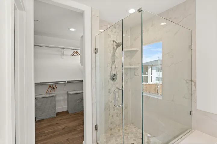 Full bath with a walk in closet, a marble finish shower, dark wood-style floors, and recessed lighting