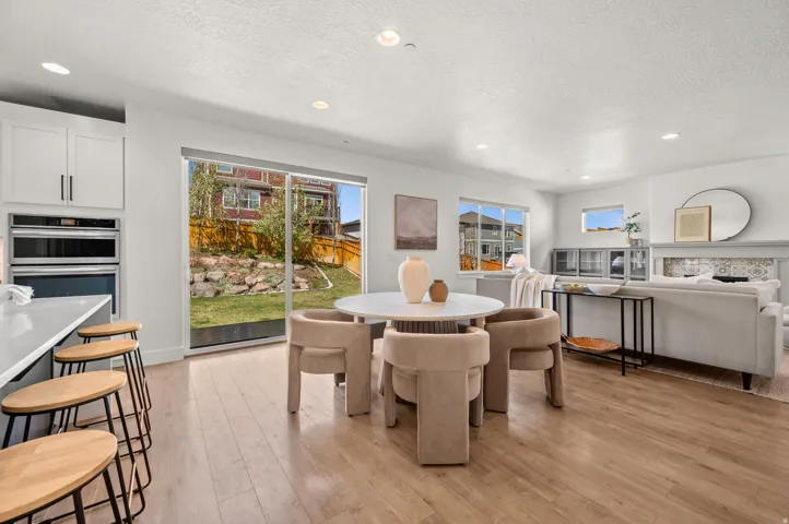 Dining space featuring light wood-style floors, recessed lighting, a fireplace, and a textured ceiling