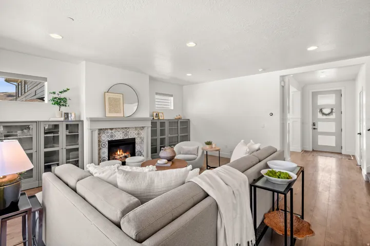Living area with a tiled fireplace, recessed lighting, hardwood / wood-style flooring, and a textured ceiling