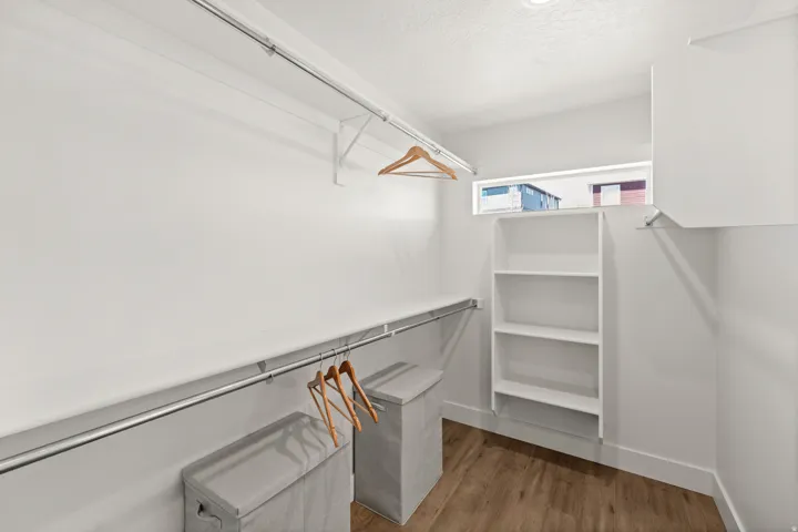 Walk in closet with light wood finished floors