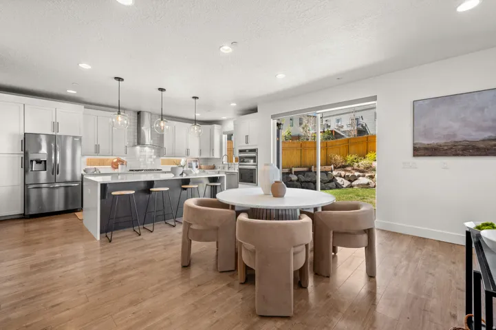 Dining area featuring light wood-style floors, recessed lighting, and a textured ceiling