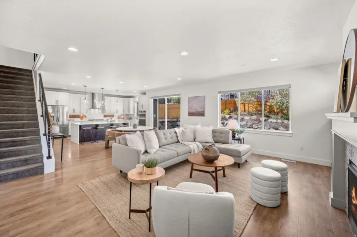 Living area featuring a lit fireplace, recessed lighting, light wood-style flooring, and a textured ceiling