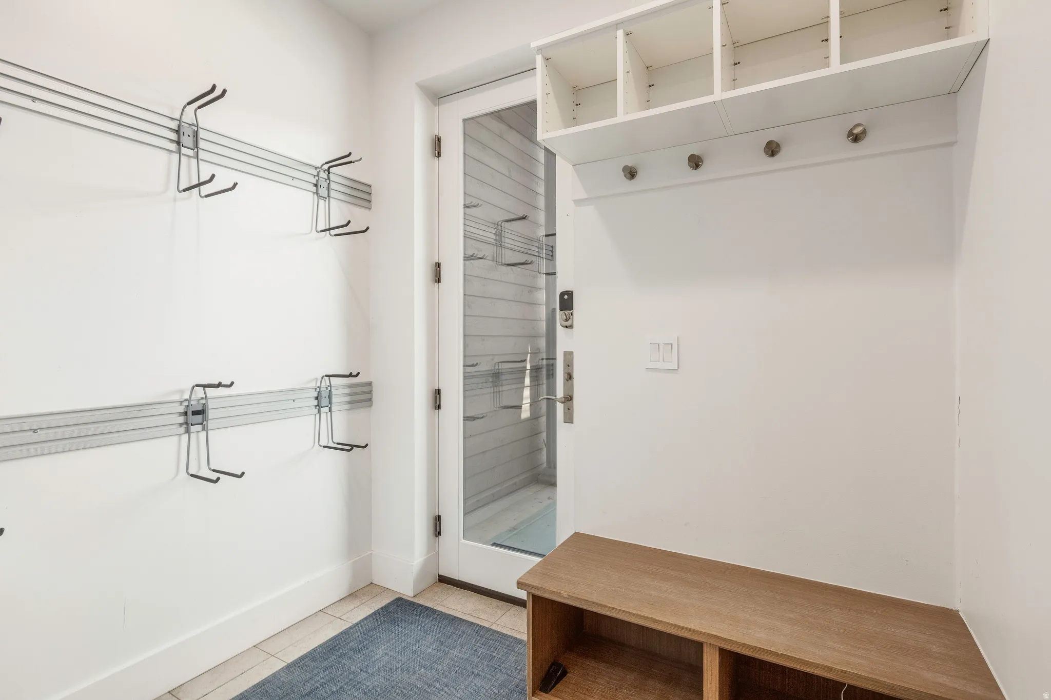 Mudroom with light tile patterned floors and baseboards