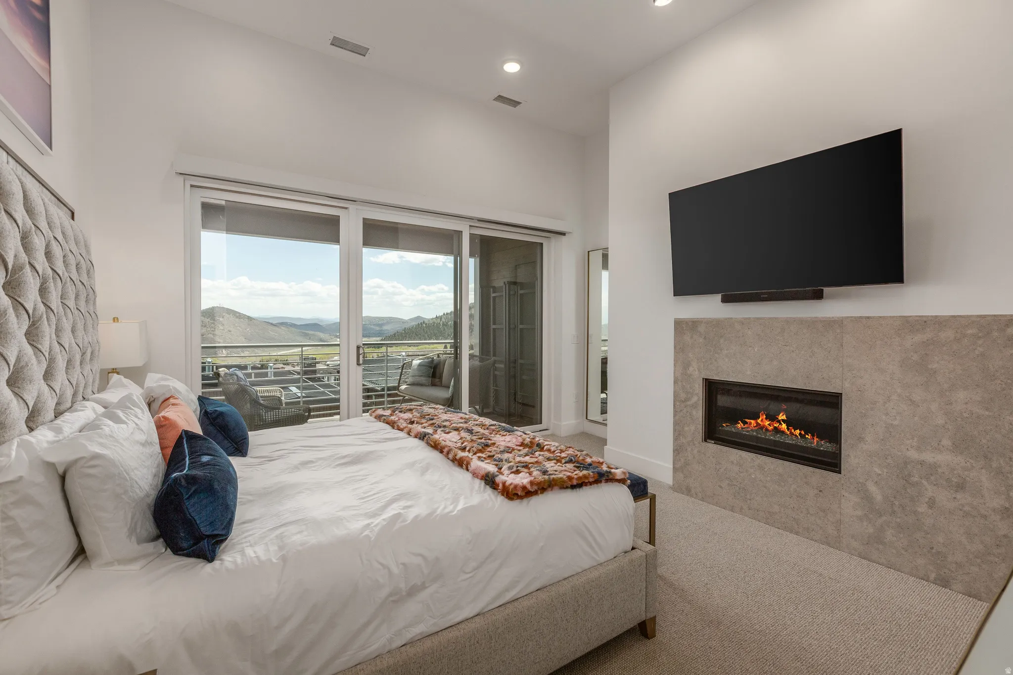 Carpeted bedroom with access to exterior, a fireplace, and recessed lighting