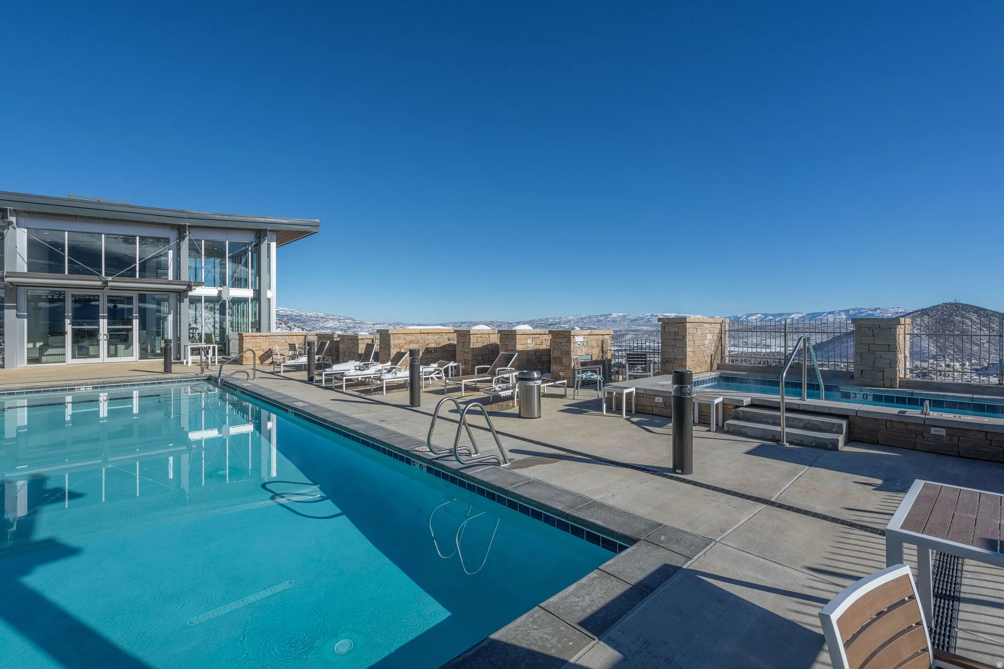 Community pool with a mountain view, a patio area, and a sunroom