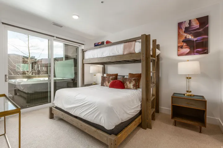 Bedroom with access to exterior and light colored carpet