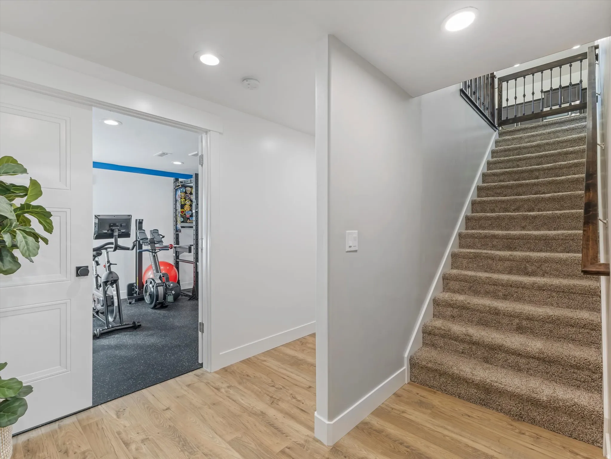 Stairway with wood finished floors and recessed lighting