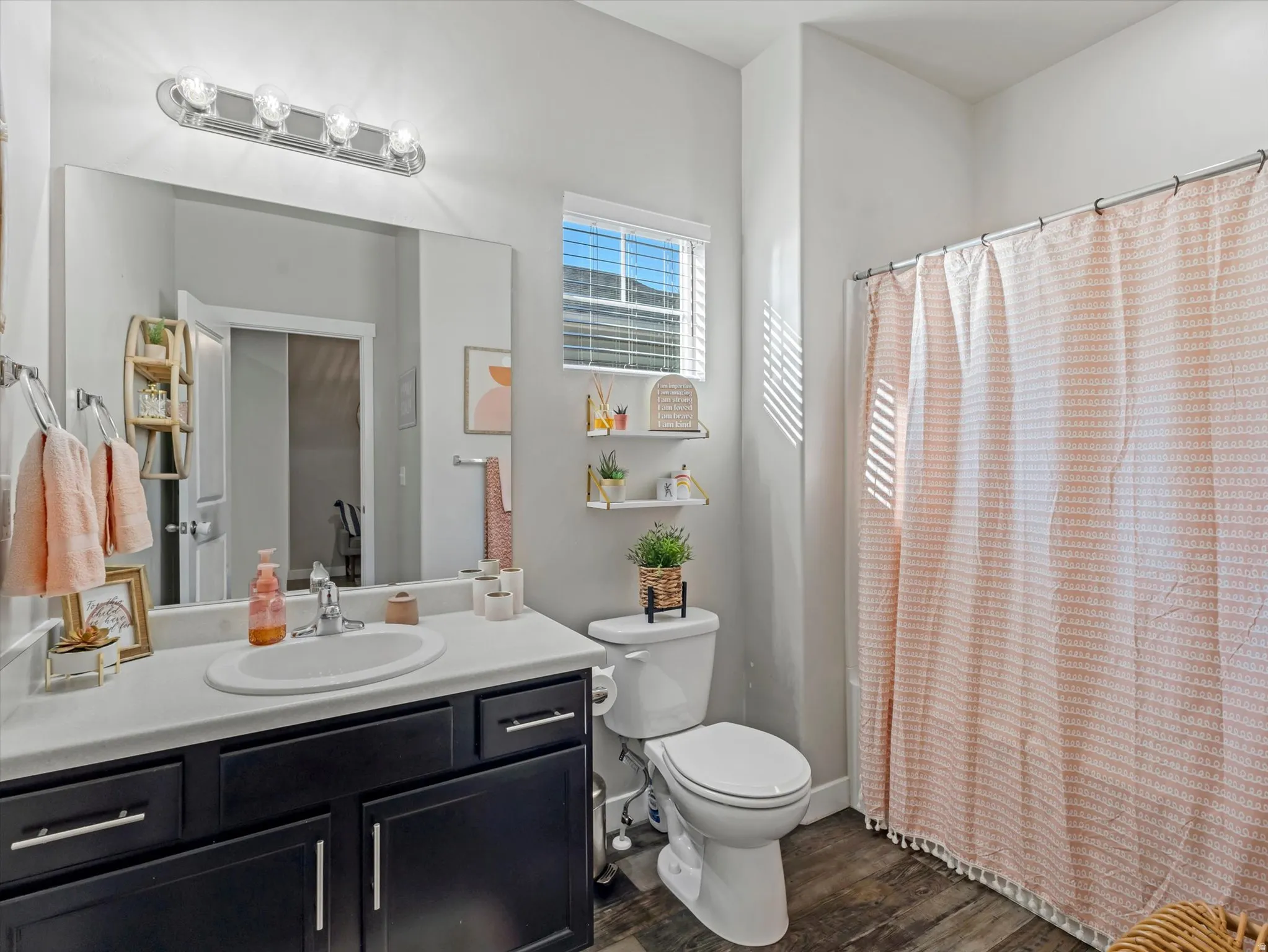 Full bath featuring vanity, dark wood finished floors, and shower / tub combo