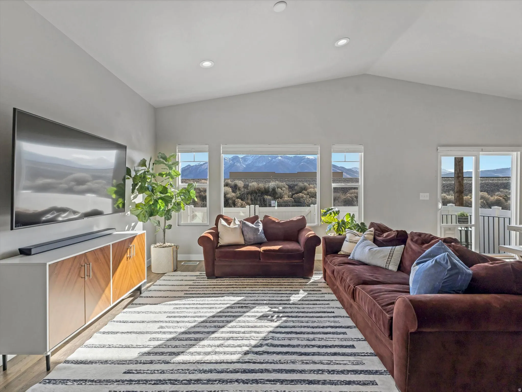 Living area with lofted ceiling, recessed lighting, and light wood finished floors