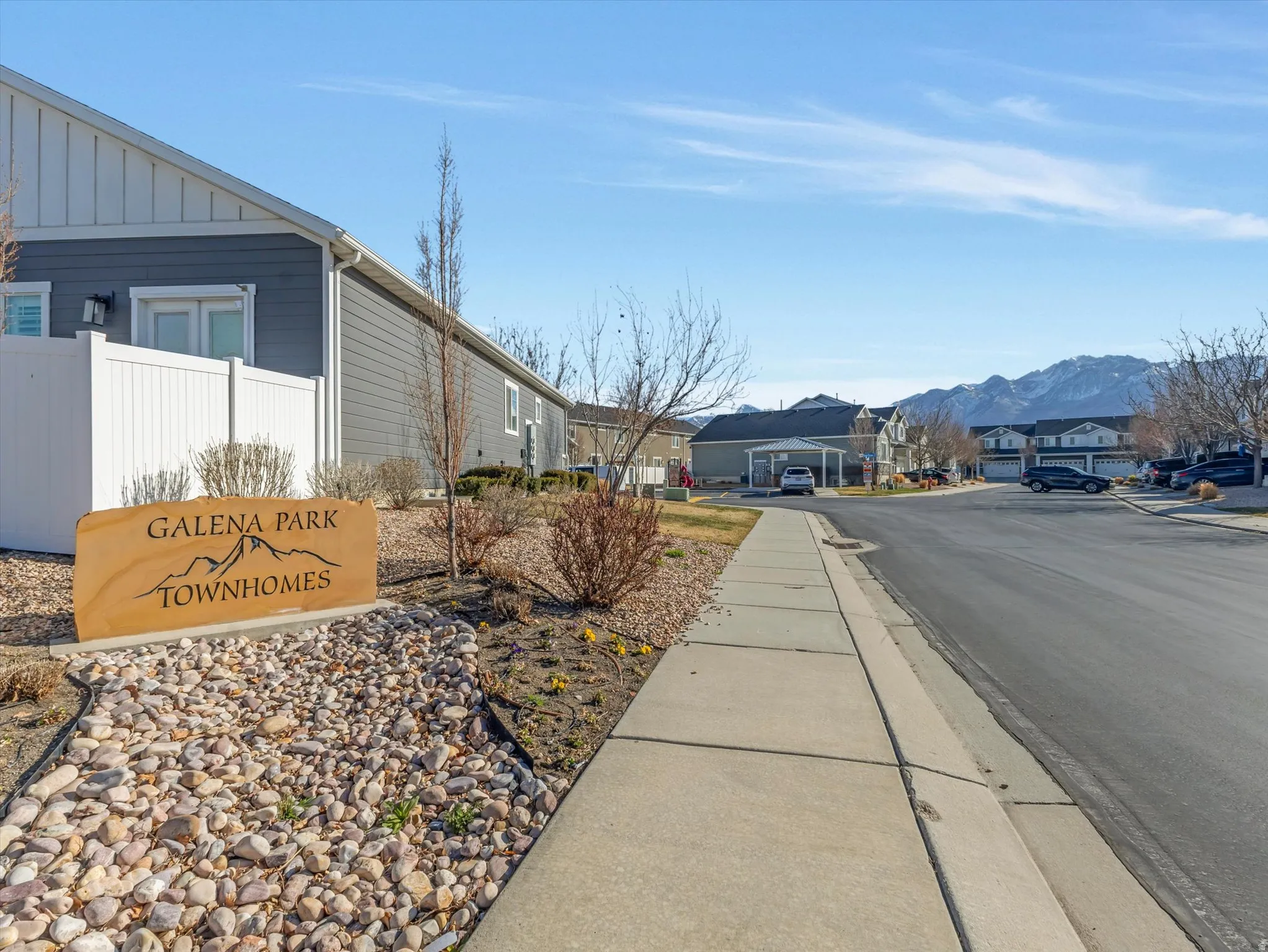 View of asphalt street with a residential view, sidewalks, and curbs